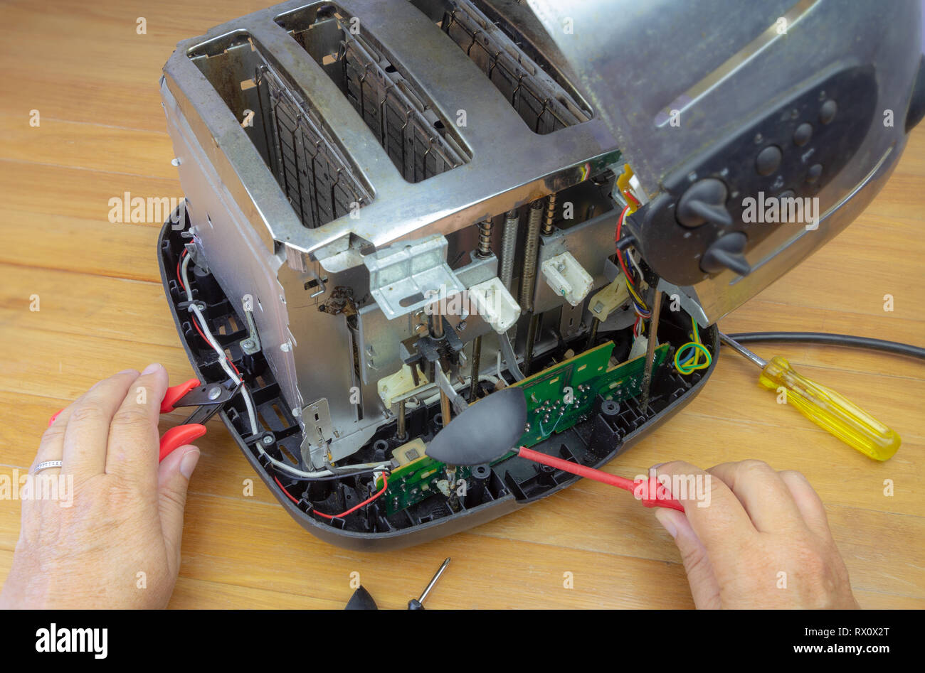 Konzept Reparaturen, Bild mit Händen der Verbraucher Instandsetzung Toaster mit Tools. Reduzieren Sie Abfälle mit der Reparatur von Haushaltsgeräten. Stockfoto