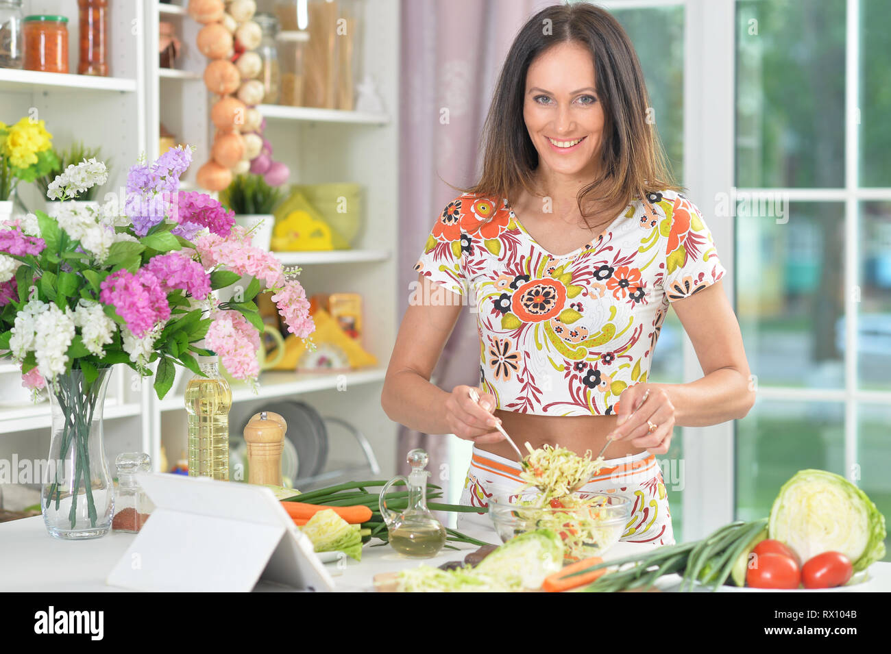Porträt der jungen Frau bereitet leckeres gesundes Essen in der Küche Stockfoto