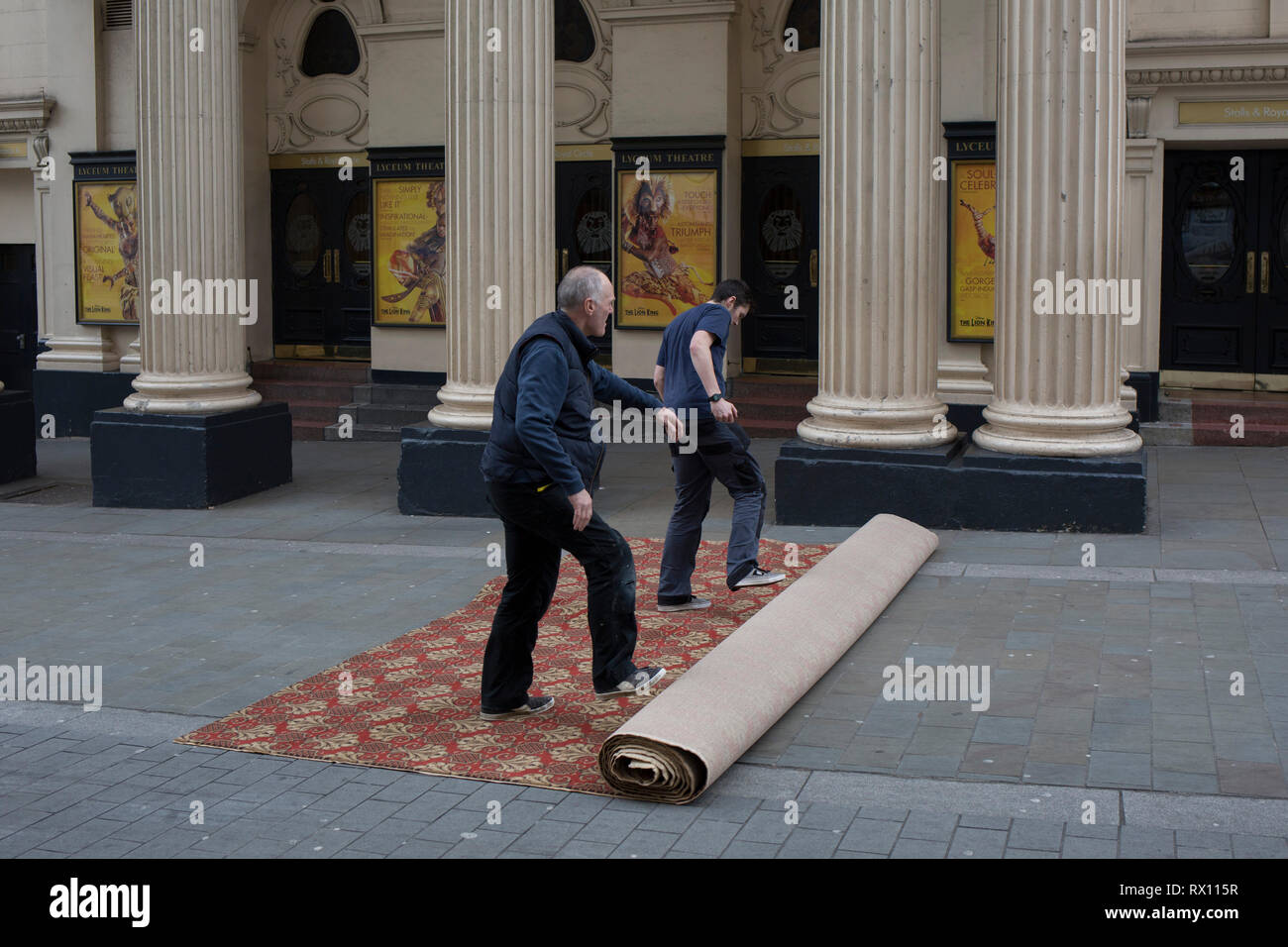 Teppich Monteure entrollen Ein neuer Teppich in der Straße für den Innenraum des Lyceum Theatre auf der Wellington Street, am 5. März 2019 in London, England. Stockfoto