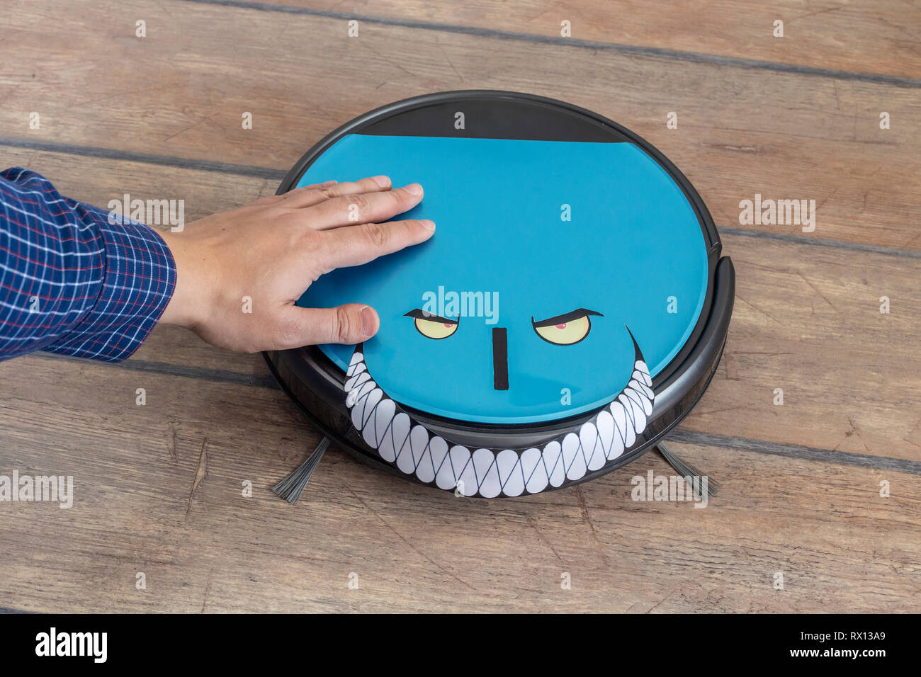 Hand petting einen Roboter Staubsauger. Böse Roboter und Übernahme Konzept. Stockfoto