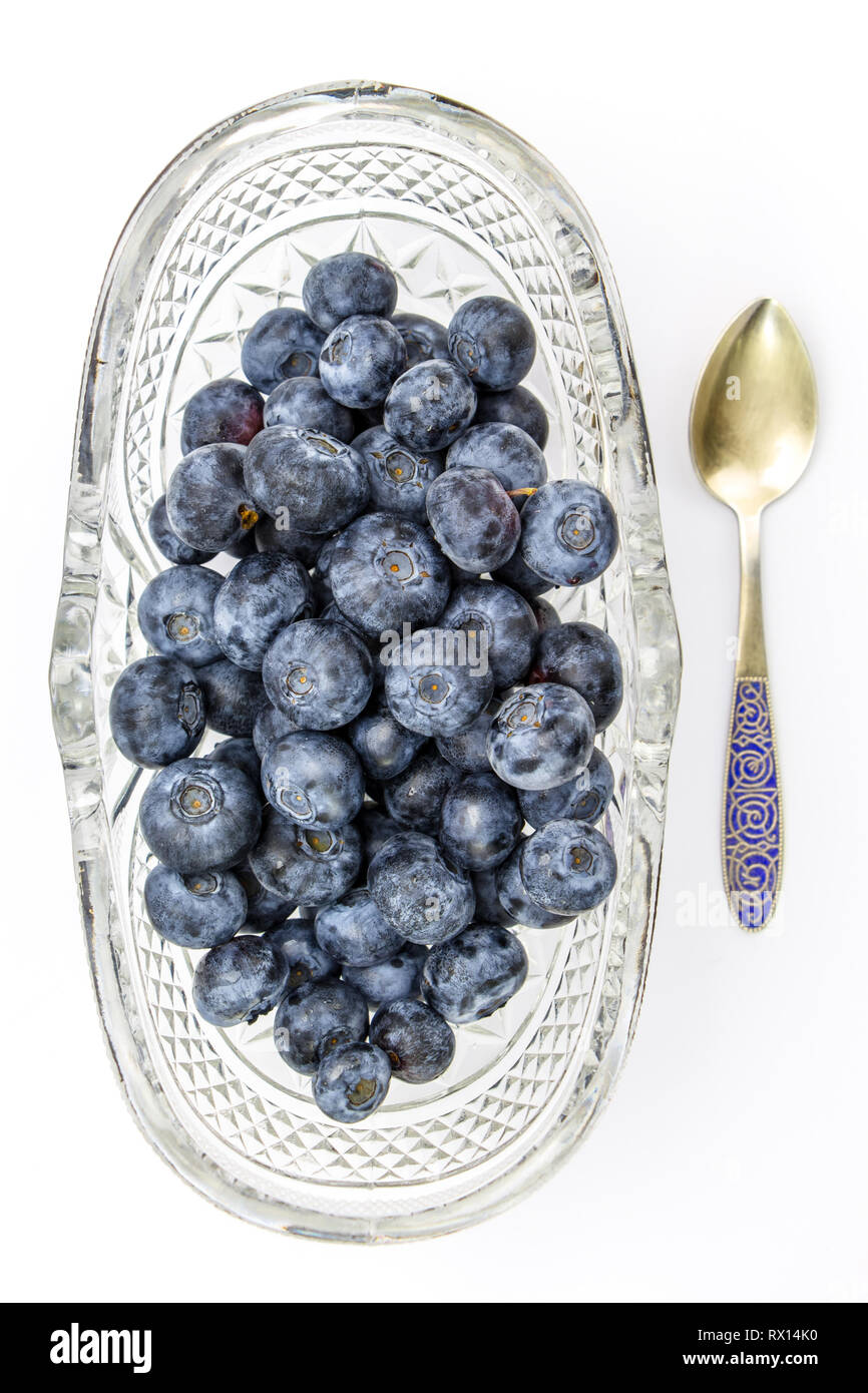 Frische Heidelbeeren im ovalen Glas dessert Schüssel und Löffel Stockfoto