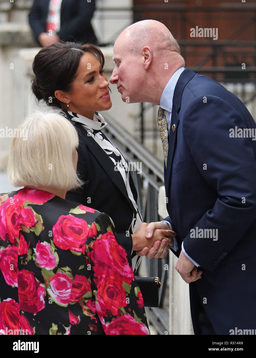 Die Herzogin von Sussex wird von Herrn Geidt, ehemaliger Privatsekretär der Queen und Queen's Commonwealth Trust Vorsitzender, wie sie für eine Podiumsdiskussion, die von der Königin Commonwealth Trust einberufen der Internationale Tag der Frau am King's College in London Mark kommt, begrüßt. Stockfoto