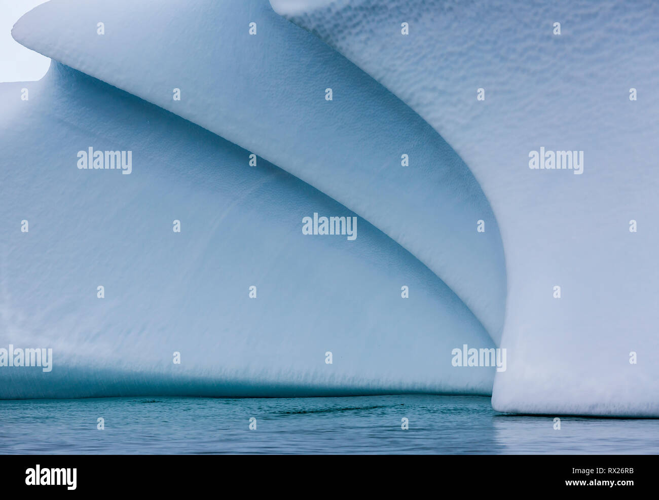 Ein geerdeter Eisberg zeigt wunderschöne weiche geschwungene Linien, während er sich langsam im flachen Wasser in der Nähe von Pleneau Island verschlechtert. Antarktische Halbinsel, Antarktis. Stockfoto
