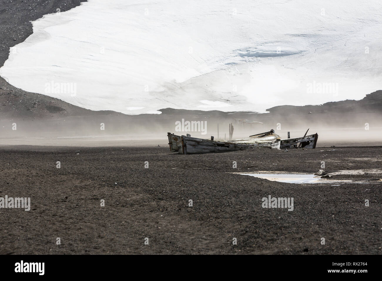 Relikte der Vergangenheit, einschließlich dieser Wasserboote, die in der Walfangindustrie verwendet wurden, liegen über den Strand von Whaler's Bay auf Deception Island, South Shetland Islands, Antarktis verstreut. Stockfoto