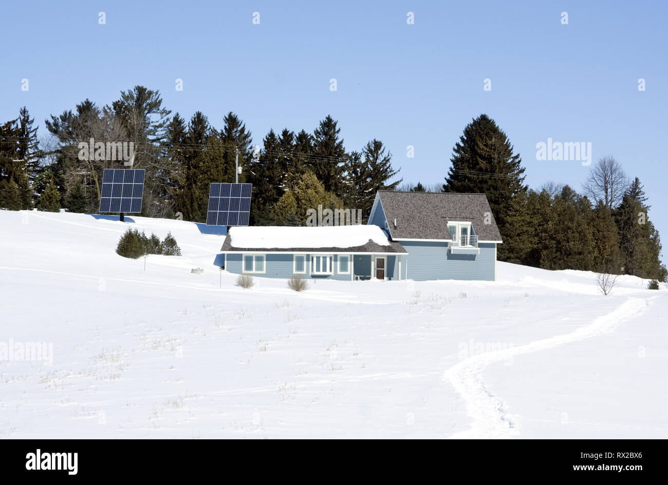 Erdgeschütztes Haus mit Photovoltaik-Solarzellen in einer ländlichen Winterumgebung. Stockfoto