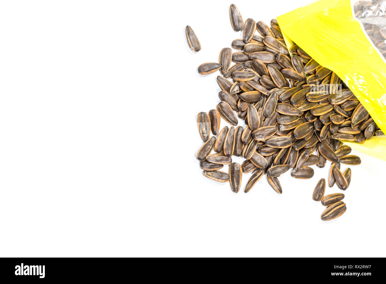 Trockene Sun Flower Samen, die aus Plastiktüten ausgegossen werden auf weißem Hintergrund. Stockfoto