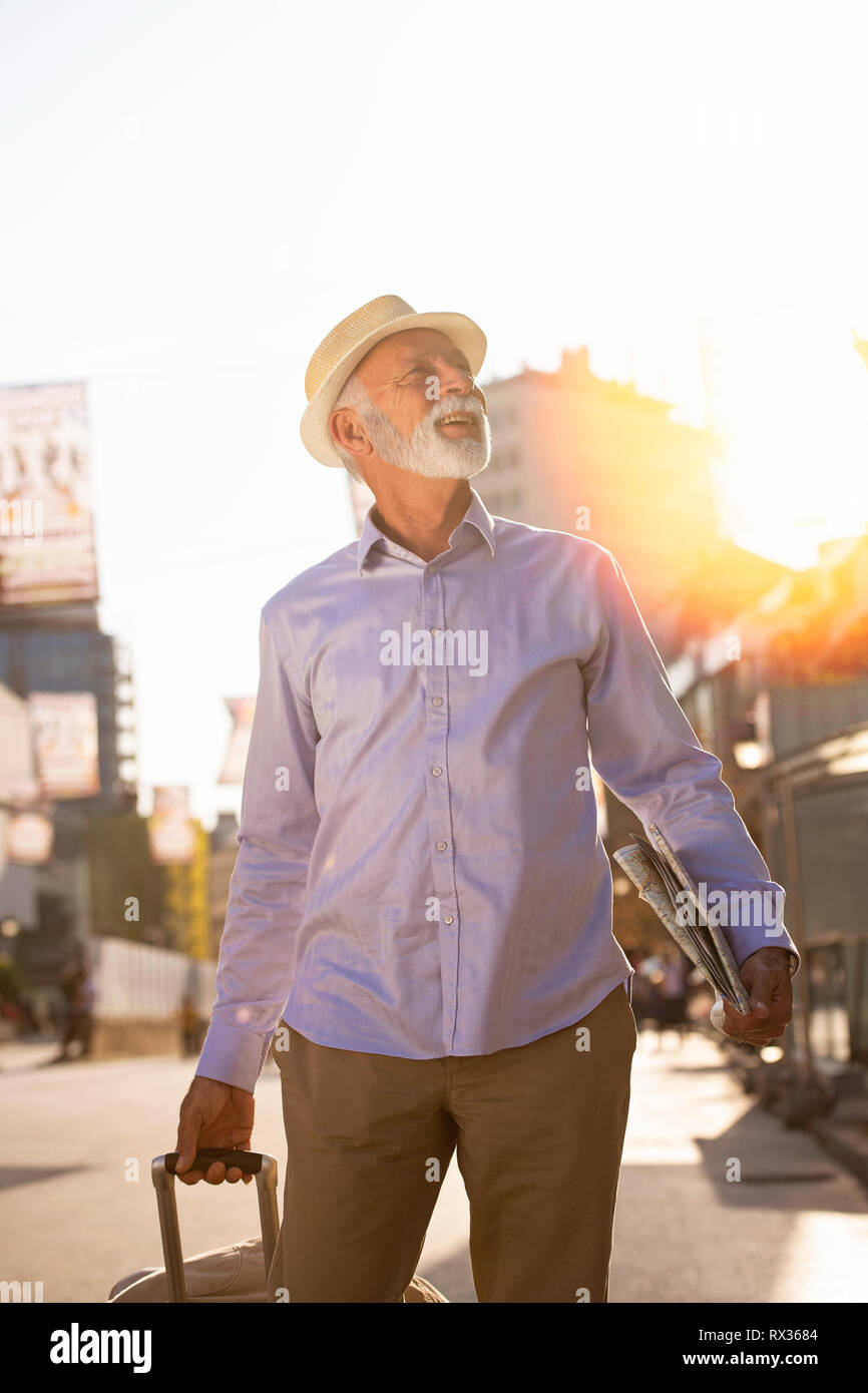 Happy Senior touristische Mann mit Koffer in die Stadt. Stockfoto