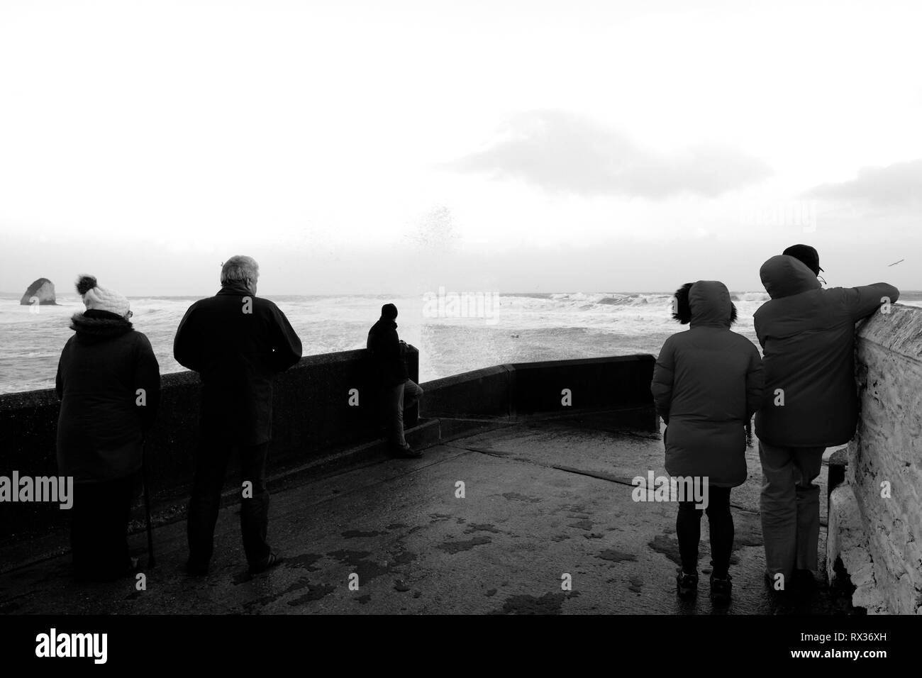 Eine Gruppe von Menschen beobachten das Wetter und die Wellen an der Freshwater Bay auf der Isle of Wight, Großbritannien. Stockfoto