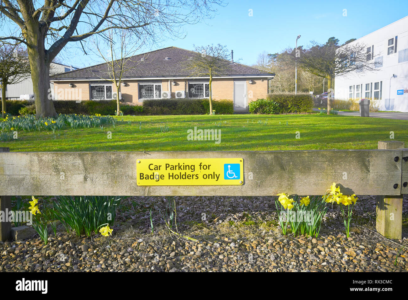 "Parkplatz für blue badge Inhaber nur' Schild am Lakeside Health Campus gegenüber dem See zum Bootfahren in Corby, England. Stockfoto