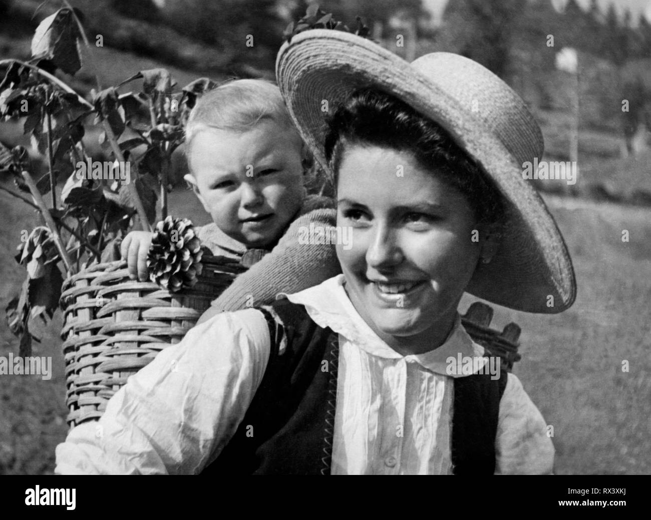 Italien, Venetien, Sovramonte Mädchen mit dem Baby im Korb, 1954 Stockfoto