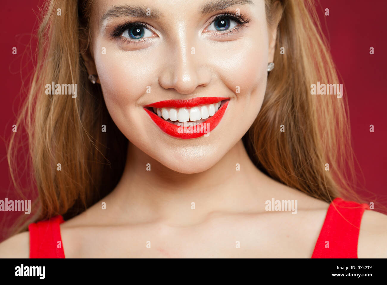 Junge schöne Mädchen mit niedlichen Lächeln Nahaufnahme. Lächelnde Frau mit roten Lippen Make-up Portrait Stockfoto