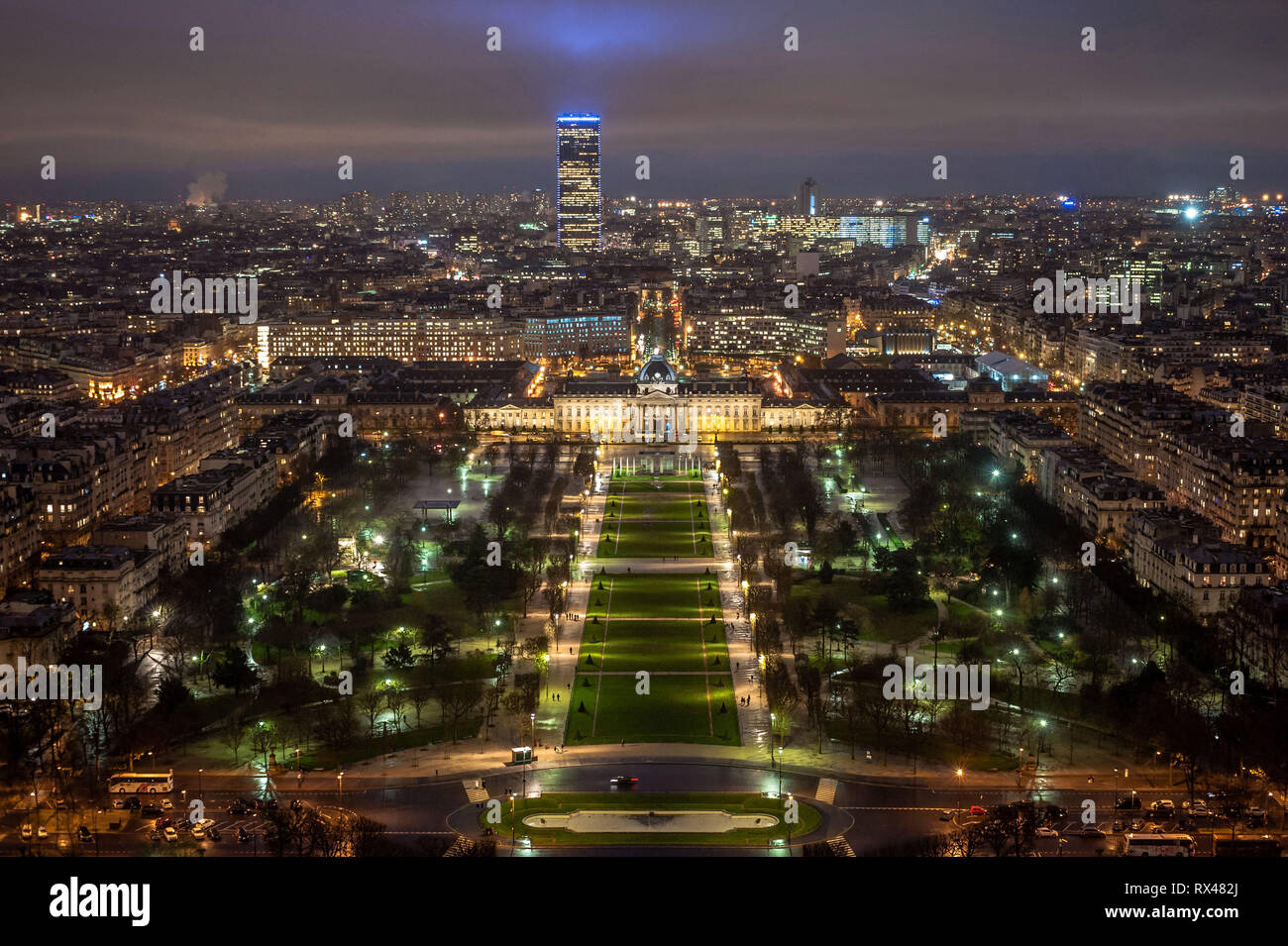 Paris (Frankreich): Champ-de-Mars, großen öffentlichen Raum vom Eiffelturm bei Anbruch der Dunkelheit gesehen. Die ÒTour MontparnasseÓ Hochhaus im Hintergrund. Stockfoto