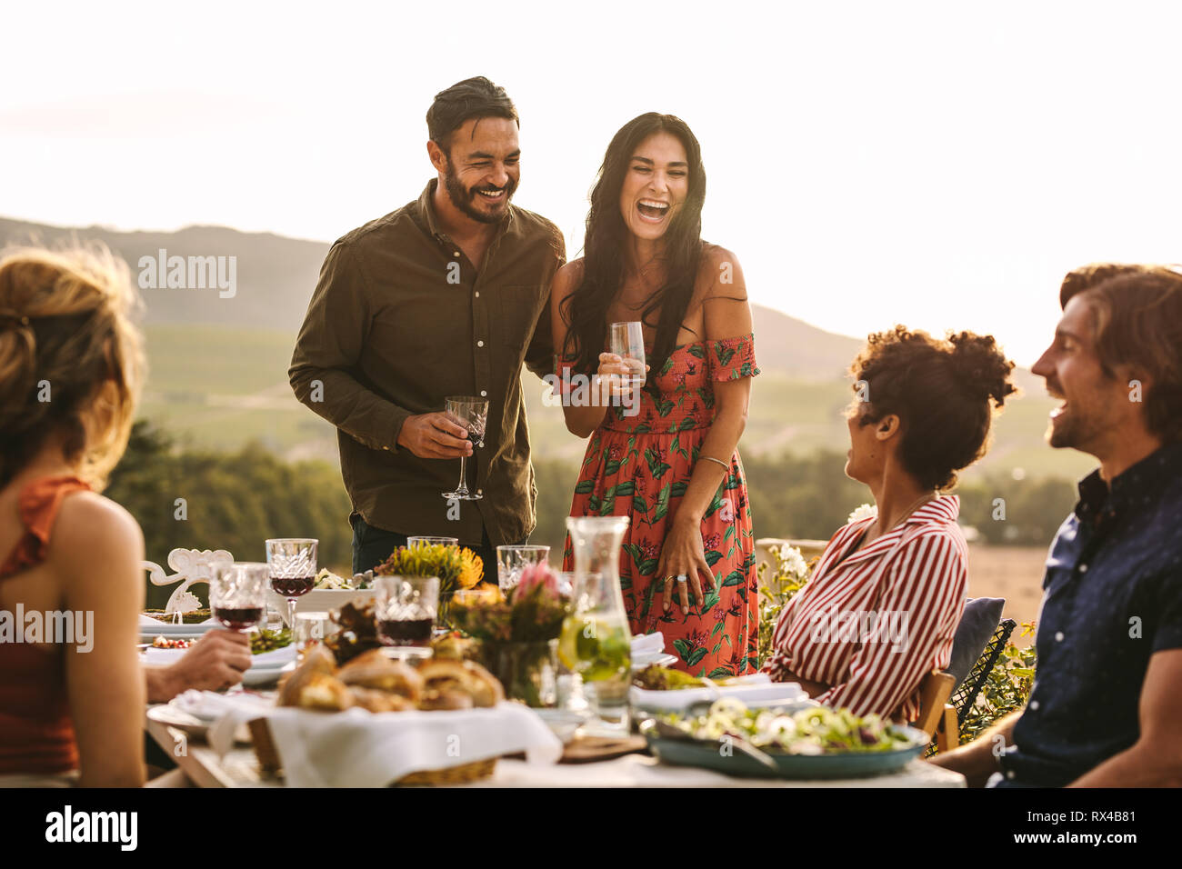 Schönes Paar an einer Partei ihre Ehe Angebotbetrags an Ihre Freunde. Lächeln, Mann und Frau, die eine Ansage bei einer Party im Freien. Stockfoto