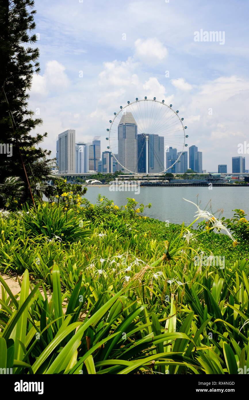 Blick auf die Stadt von Singapur mit Gärten in den Vordergrund und Gebäude und Flyer im Hintergrund, Singapur Stockfoto