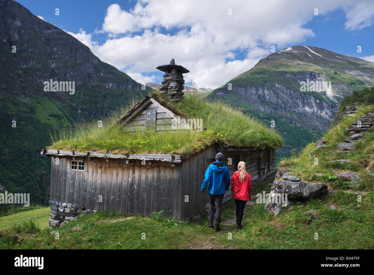 Kagefla - historische Bergbauernhöfen auf die Berghänge entlang der Geiranger Fjord. Touristische Attraktion von Norwegen. Ein paar Reisende, tr Stockfoto