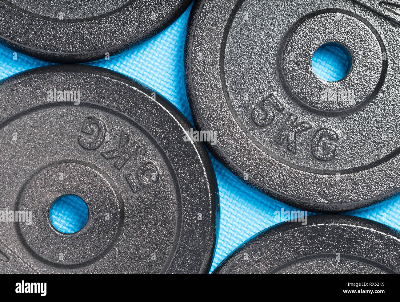 Gewicht Platten auf einem bunten blauen Boden, innen, ein Krafttraining Fitness Studio Stockfoto