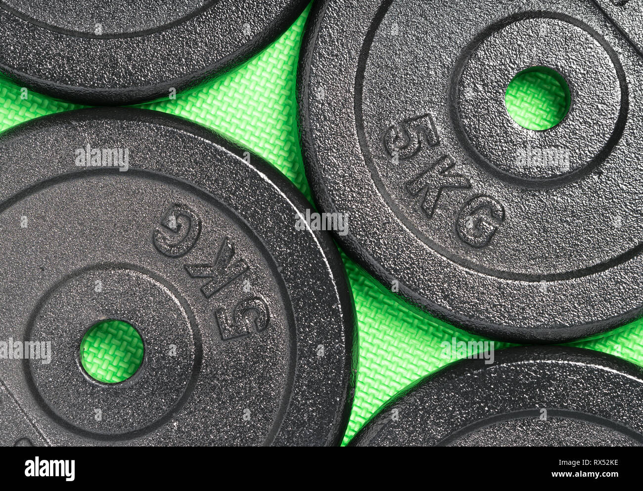 Gewicht Platten auf einem bunten grün Boden, innen, ein Krafttraining Fitness Studio Stockfoto