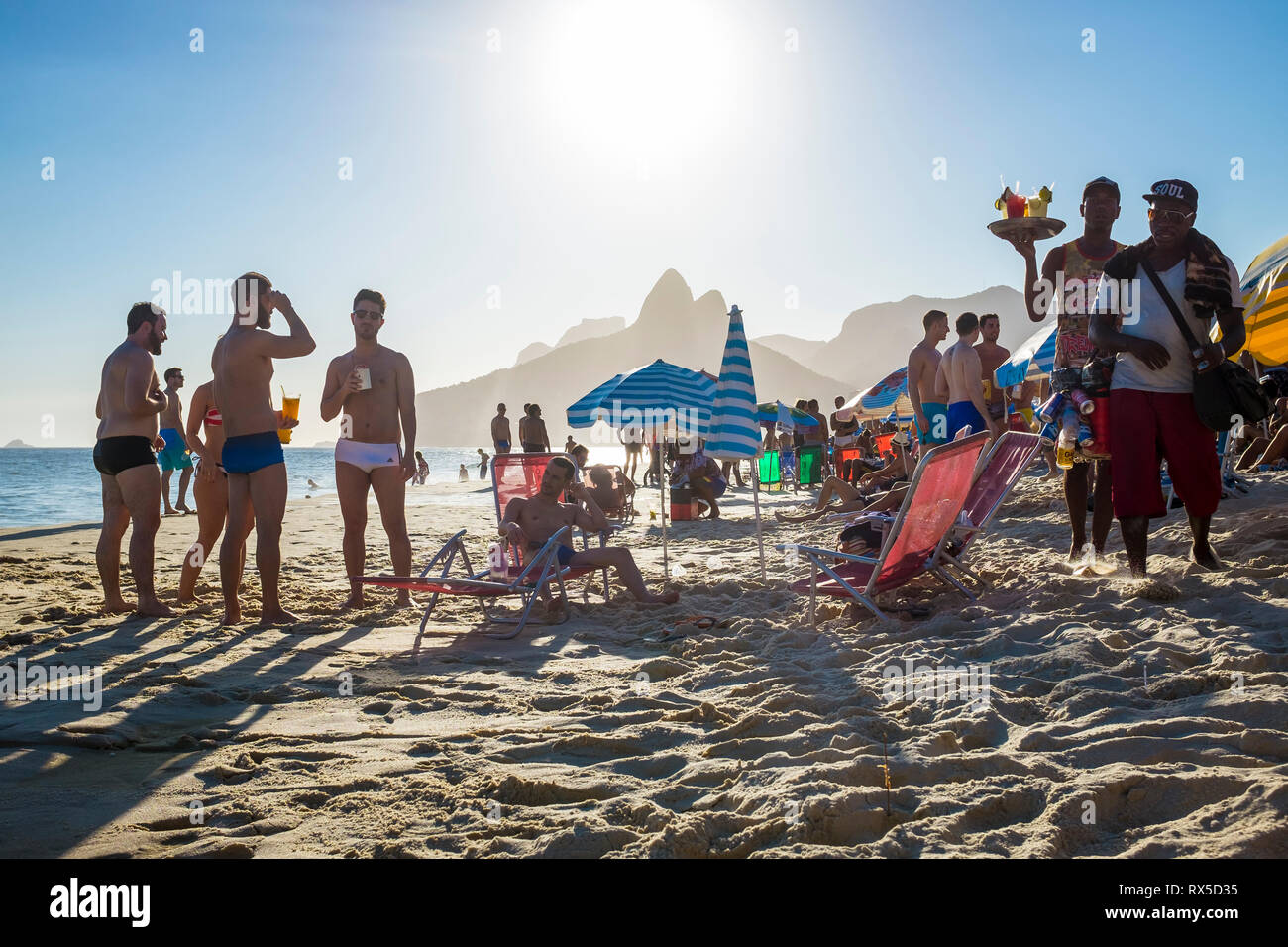 RIO DE JANEIRO - Februar 5, 2017: Unlicensed Strand verkäufer, Bier und hausgemachten Caipirinha cocktails Spaziergang am Strand von Ipanema auf der Suche nach Kunden Stockfoto