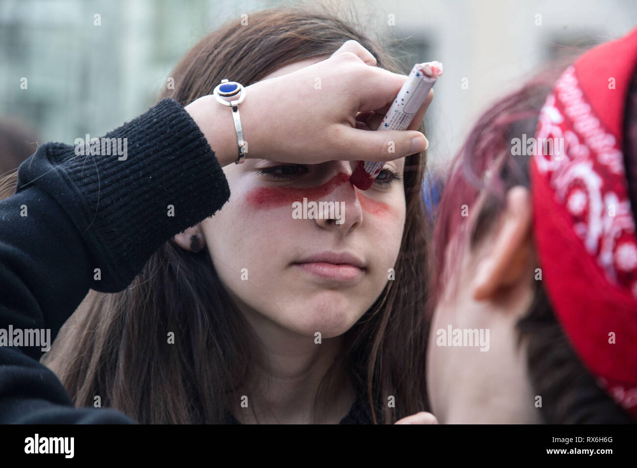 Feministinnen bereiten Sie sich auf die große Demonstration durch das malen ihre Gesichter bei Tag Protest des Internationalen Frauen in Madrid. Tausende von Frauen protestieren gegen die Ungleichheit zwischen den Geschlechtern, Prekarität, die Mitverantwortung der weder Männer noch der Staat in der Pflege arbeiten, unter anderem Diskriminierungen bei den Internationalen Frauentag. Stockfoto