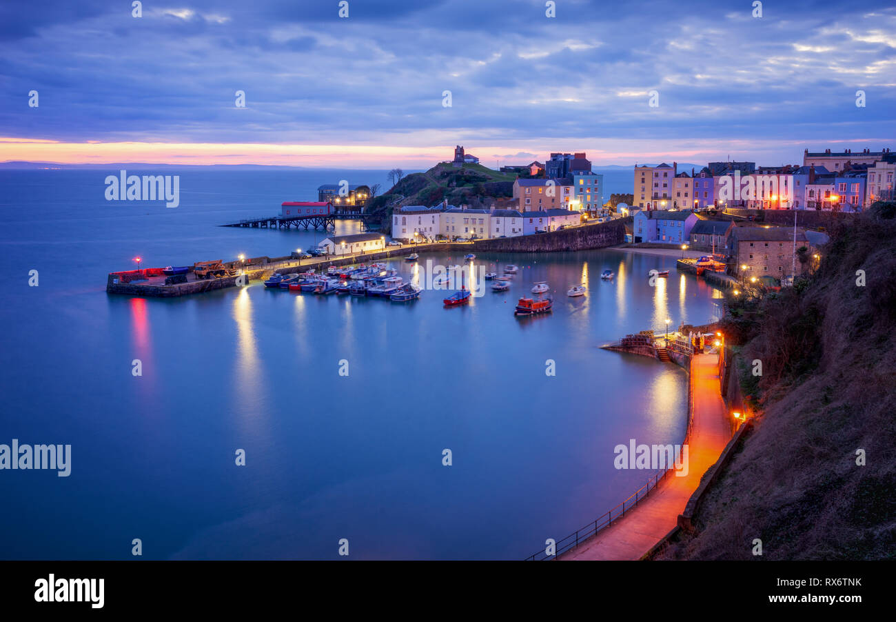 Hafen von Tenby, Wales kurz vor Sonnenaufgang, Schiffe und Gebäude in der blauen Stunde. Stockfoto