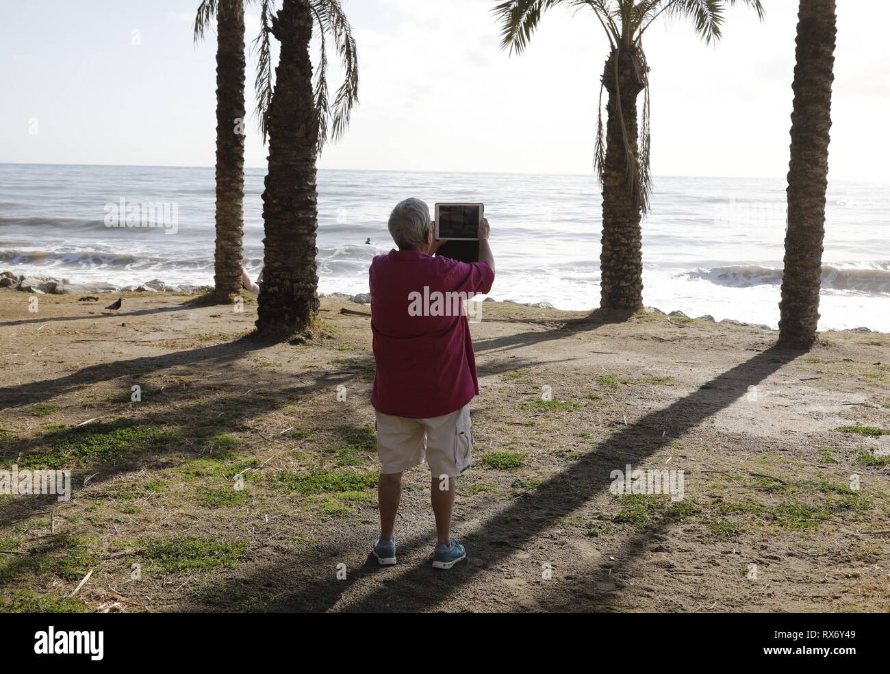 Ein Mann mit seinem Tablet ein Film am Strand in Torremolinos, Spanien, 13. Februar 2019. Die spanische Wirtschaft wartet, um zu sehen, wie der britische Zukunft Abreise aus der Europäischen Union in Spanien gelten könnten. | Verwendung weltweit Stockfoto