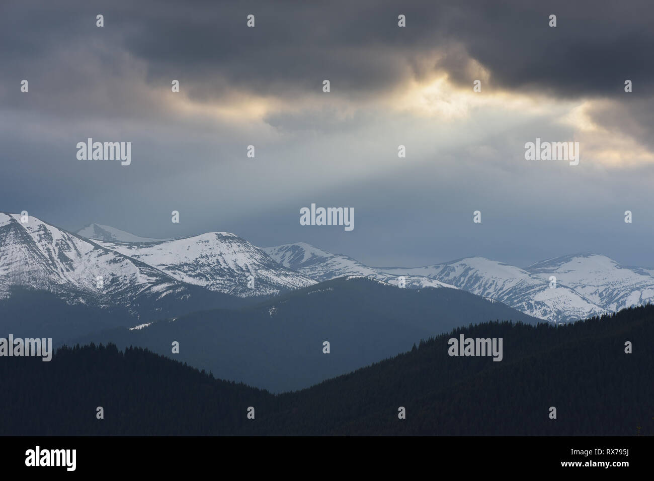 Frühling Landschaft mit stürmischen Himmel. Letzte Schnee auf den Gipfeln. Ein Strahl der Sonne von den Wolken. Karpaten, Ukraine Stockfoto