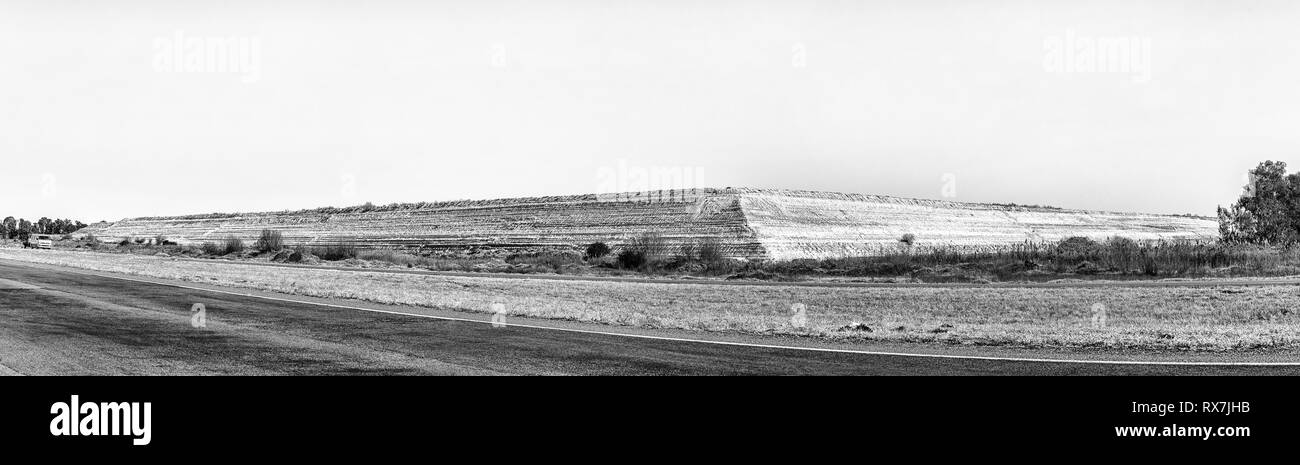 WELKOM, SÜDAFRIKA, August 2, 2018: eine Mine dump in der Nähe von Welkom in der Provinz Freistaat Provinz. Ein Fahrzeug mit Anhänger ist sichtbar. Schwarzweiß Stockfoto