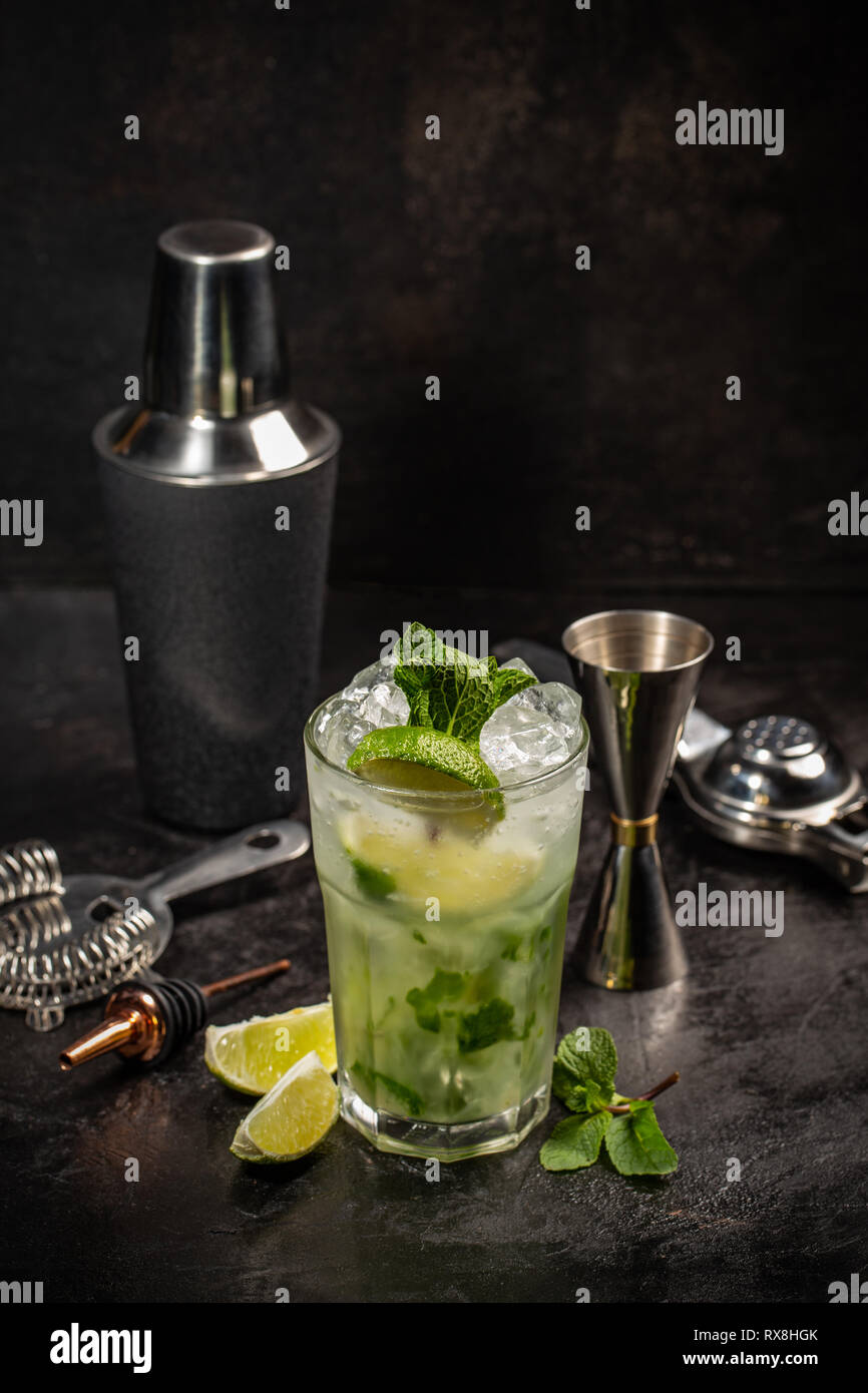 Mojito Cocktail mit Getränk und Tools auf schwarzem Hintergrund Stockfoto