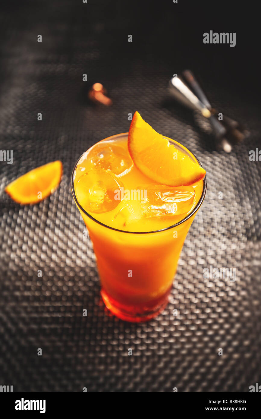 Erfrischender aperol orange Cocktail mit in Scheiben geschnittenen Orangen auf einem dunklen Hintergrund Stockfoto