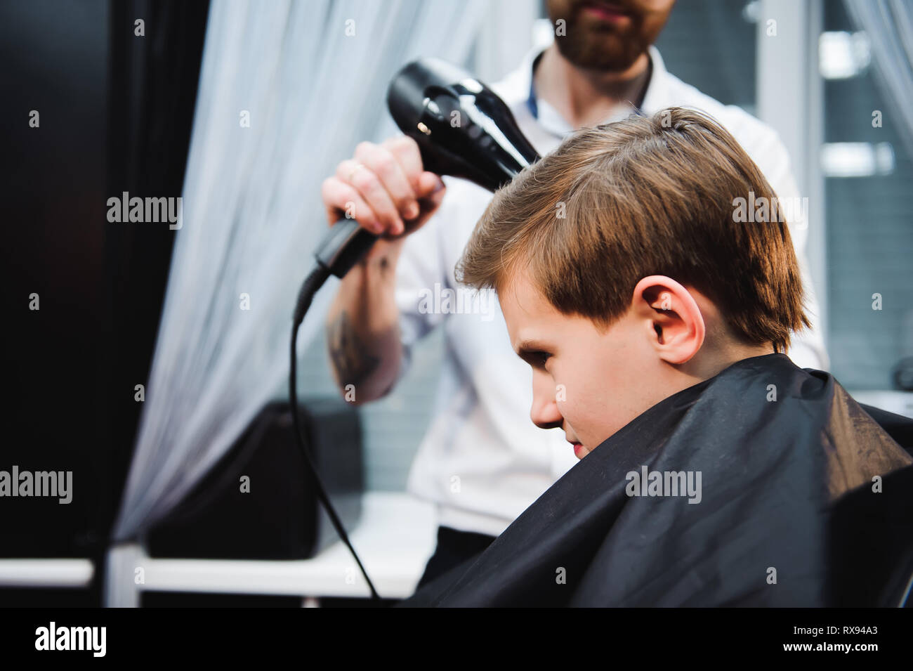 Süße kleine Junge ist, Haarschnitt, Friseur am Friseursalon. Stockfoto