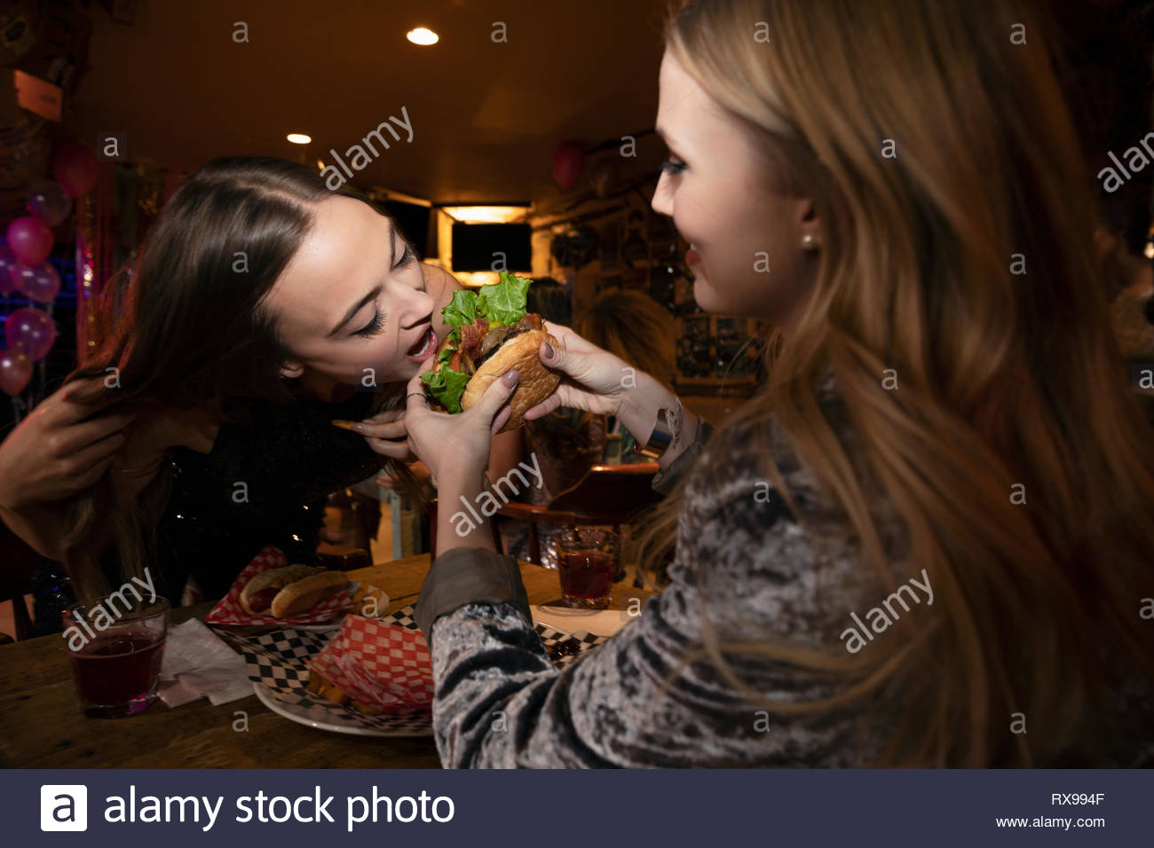 Frauen Freunde teilen Hamburger nachts spät Diner Stockfoto