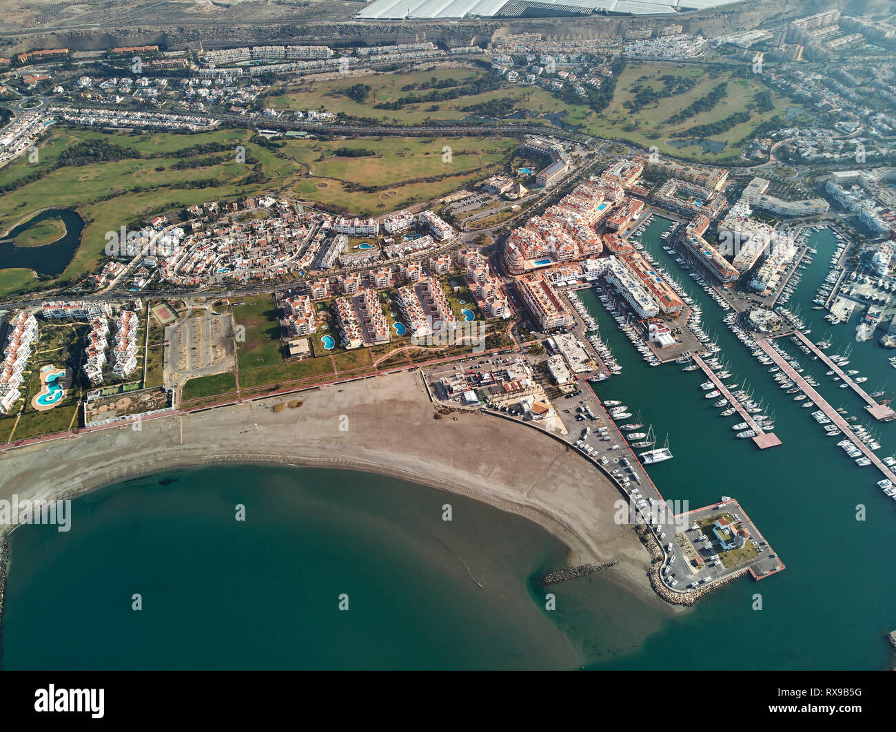 Antenne drone Punkt Panorama von Almerimar Stadtbild, Gewächshäuser, Anker nautische Schiffe in den Hafen, die Küste Sandstrand, Gemeinde E Stockfoto