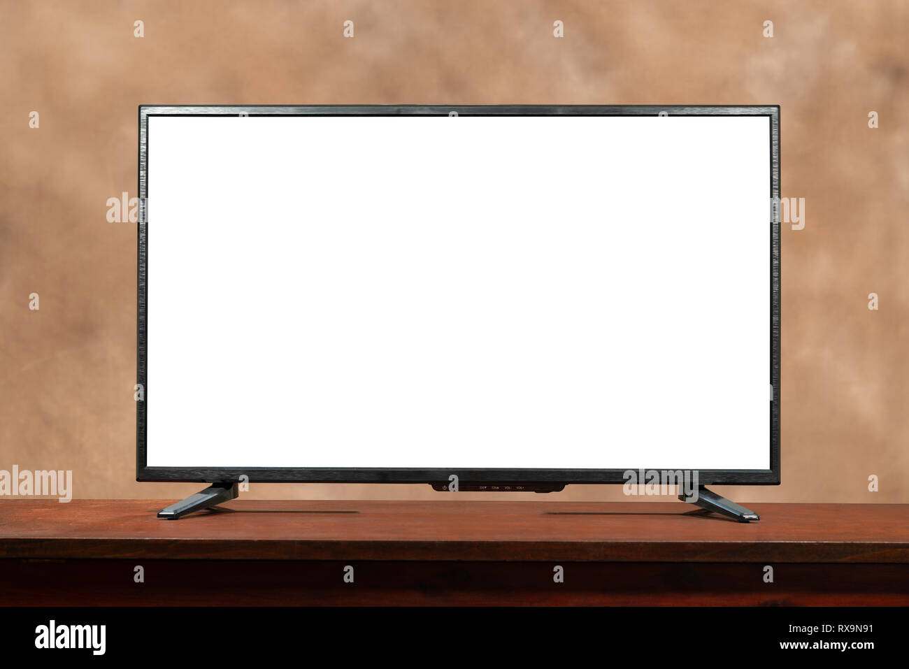 Horizontale geschossen von einem leeren großen Tv mit Kopie Platz am Tisch. Braun konfusen Hintergrund. Stockfoto