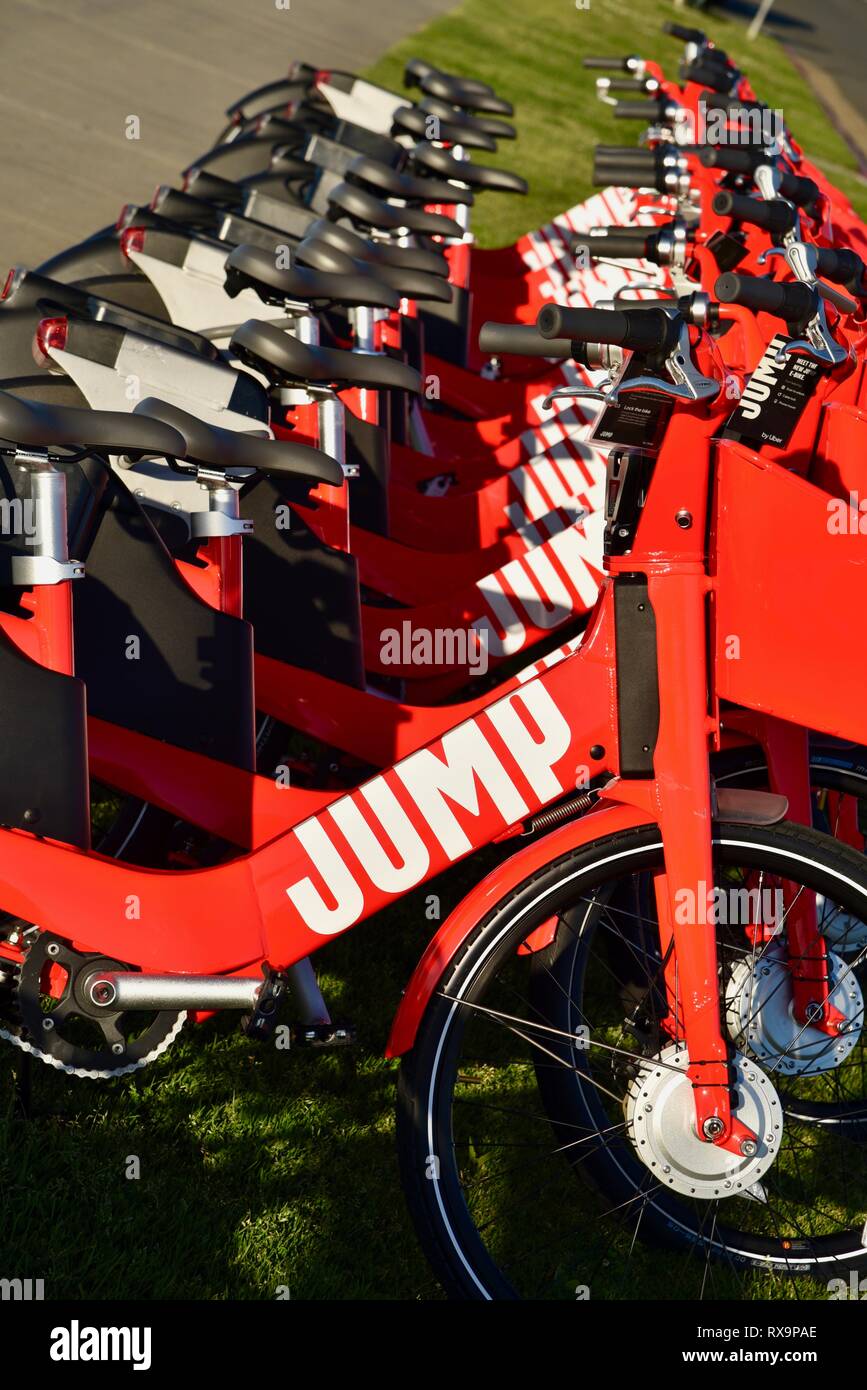 Uber Springen reiten-sharing (Fahrrad) Rot, elektrische Fahrräder (e-bikes) bis auf Gras auf Harbour Island, San Diego, USA gefüttert Stockfoto