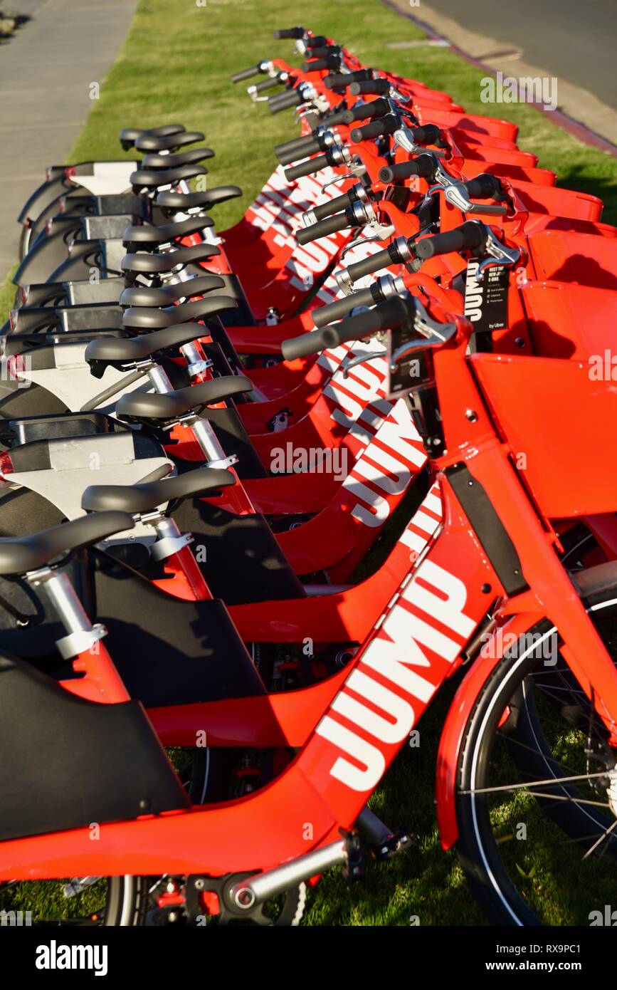 Uber Springen reiten-sharing (Fahrrad) Rot, elektrische Fahrräder (e-bikes) bis auf Gras auf Harbour Island, San Diego, USA gefüttert Stockfoto