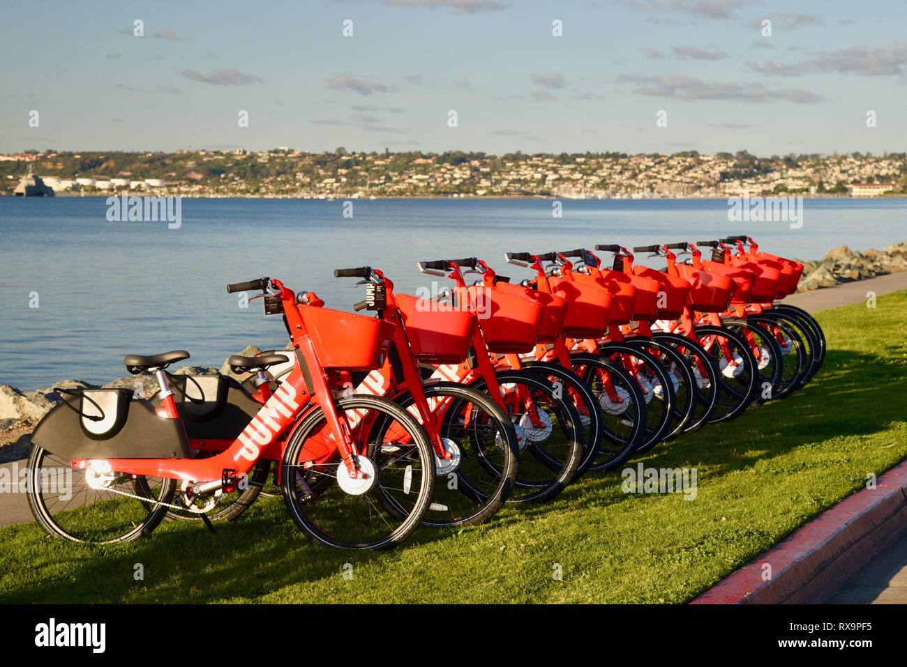 Uber Springen reiten-sharing (Fahrrad) Rot, elektrische Fahrräder (e-bikes) bis auf Gras auf Harbour Island, San Diego, USA gefüttert Stockfoto