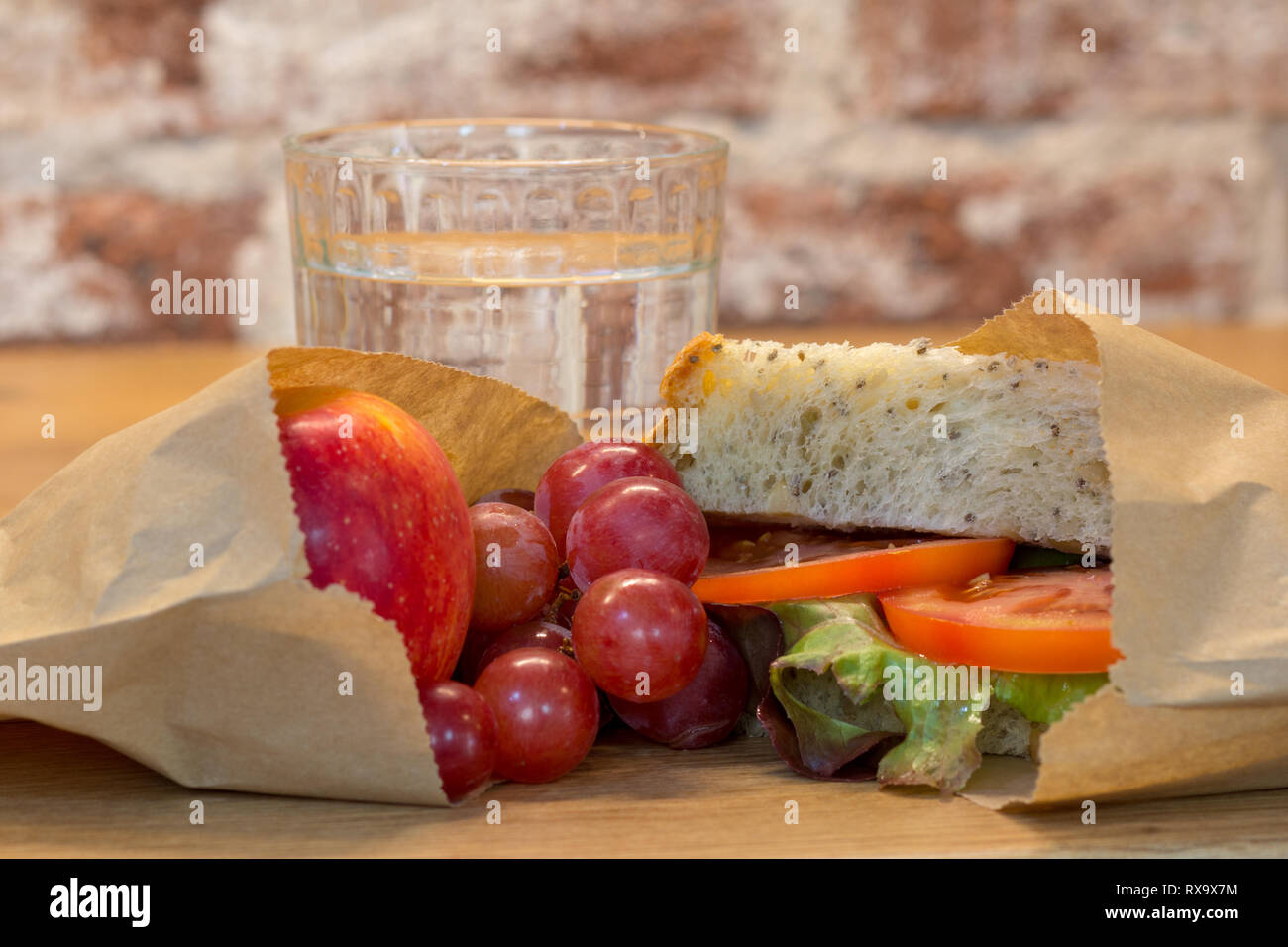 Alternative Kunststoff kostenlose gesunde Lunchpaket essen die Verwendung authentischer echte hausgemachte Speisen in braunen Papiertüten. Tomaten, hausgemachtes Brot, Trauben, Apple Stockfoto