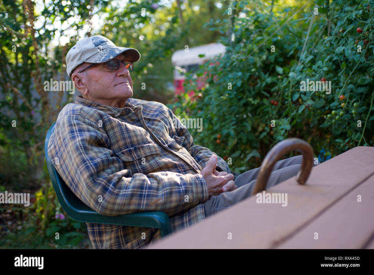 Älterer Mann mit Kappe im Hinterhof ruhen Stockfoto