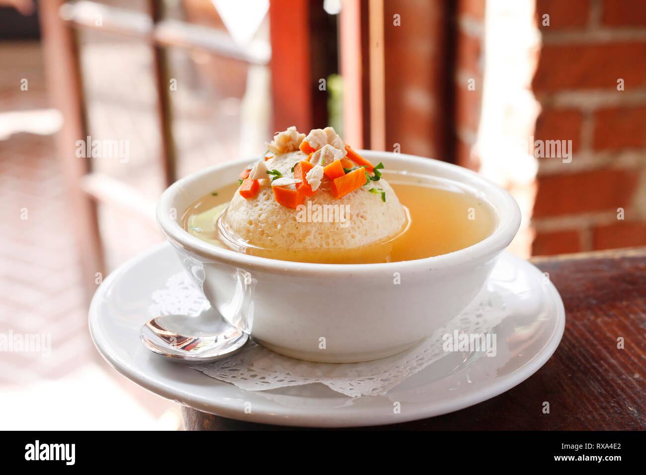 Nahaufnahme der Suppe in Schüssel mit Teller und Löffel am Tisch serviert Stockfoto