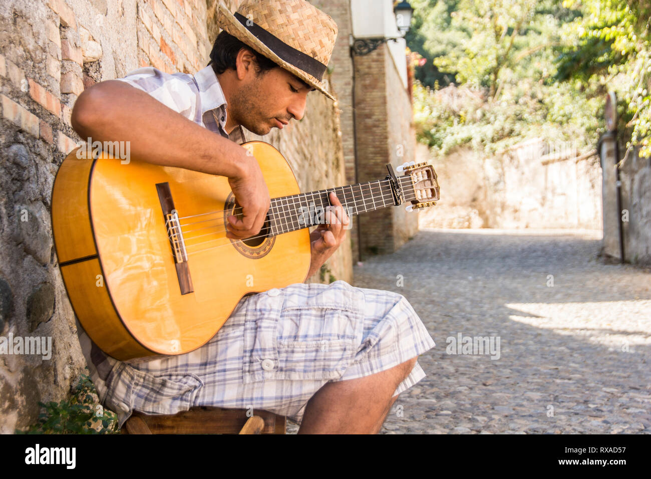 Ein junger Mann in Spielen Flamenco Gitarre seinen Anfang 20 in einer Gasse; Granada, Spanien. Stockfoto