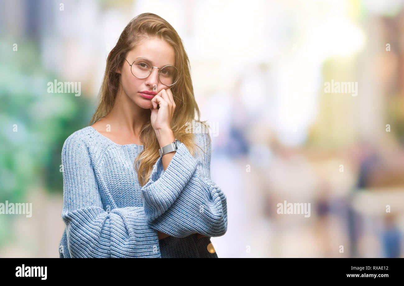 Junge hübsche blonde Frau mit Pullover und Gläser über isolierte Hintergrund denken müde und mit Depressionen Probleme mit Kreuz gebohrt Stockfoto