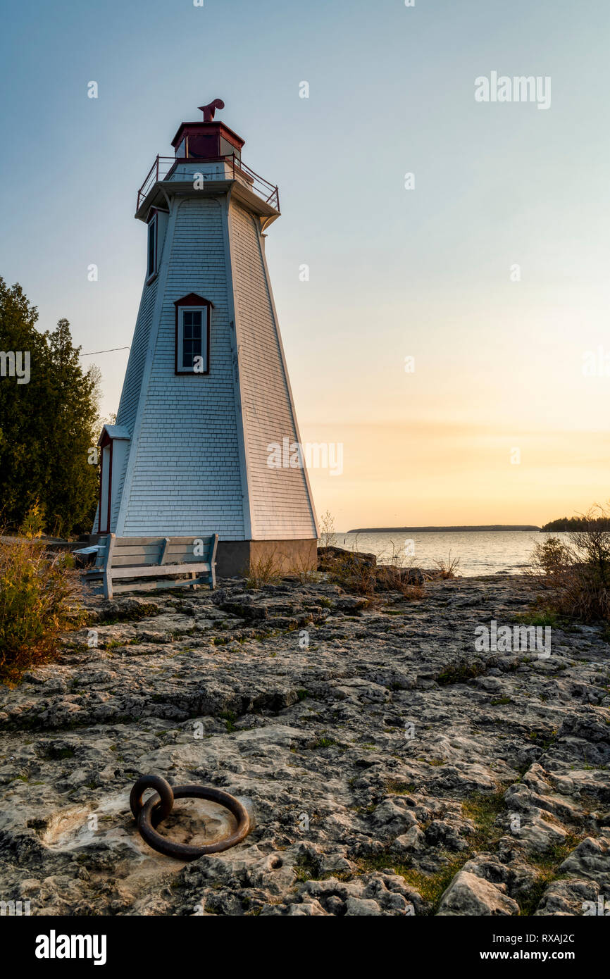 Sonnenaufgang und dem historischen Leuchtturm am grossen Whirlpool Hafen. Dock ring in Rock wurde verwendet, um Schiffe Zuflucht nehmen Stürme zu binden. Tobermory, Ontario, Kanada Stockfoto Sonnenaufgang und dem historischen Leuchtturm am grossen Whirlpool Hafen. Dock ring in Rock wurde verwendet, um Schiffe Zuflucht nehmen Stürme zu binden. Tobermory, Ontario, Kanada Stockfoto