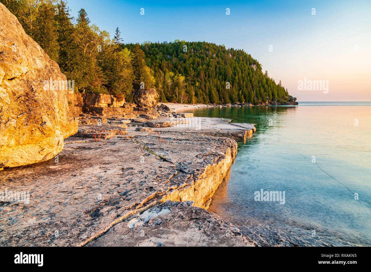 Slabbed Kalkstein Küstenlinie von Blumentopf Insel ist Gold von der aufgehenden Sonne über Georgian Bay, Fathom Five National Marine Park, Ontario, Kanada, getönt Stockfoto