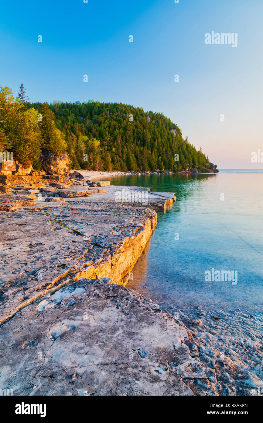 Slabbed Kalkstein Küstenlinie von Blumentopf Insel ist Gold von der aufgehenden Sonne über Georgian Bay, Fathom Five National Marine Park, Ontario, Kanada, getönt Stockfoto