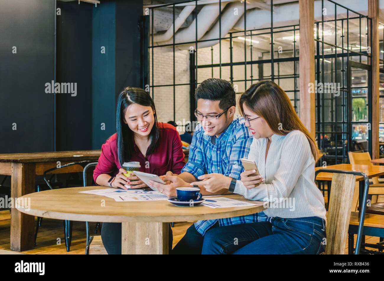 Gruppe von asiatischen Geschäftsleuten mit lässiger Anzug Brainstorming in Entspannen Im modernen Coffee Shop, Business Group Konzept Stockfoto