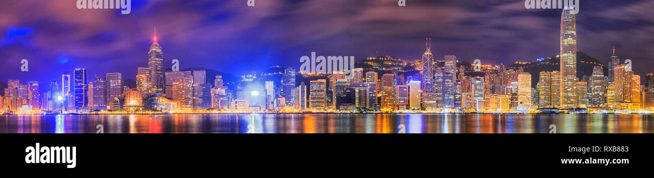 Dunkle pre-dawn Panorama in Hong Kong City auf der Hong Kong Insel CBD Wahrzeichen und hoch aufragenden Türmen gegen bewölkt blauer Himmel mit helle Beleuchtung refle Stockfoto