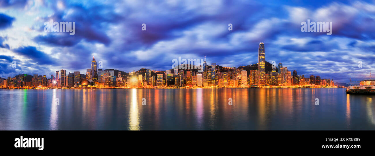Stadtbild von Hong Kong City CBD um Zentrale auf der Insel Hong Kong am Fuß der Hügel mit der Reflexion von Licht in Gewässern des Victoria Harbour bei Sun Stockfoto