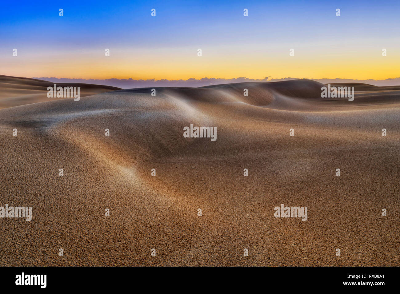 Sonnenaufgang morgen Sonne Licht über leblos unberührte Sanddünen in verlassenen Gegend von Stockton Strand in Australien - abgelegenen Teil des Nationalparks mit Regen Stockfoto