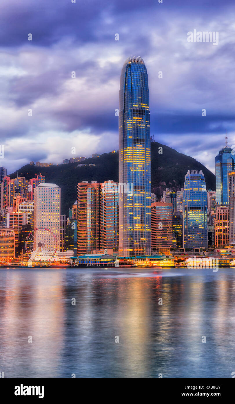 Das höchste Hochhaus Tower auf der Hong Kong Stadtbild im Zentrum von CBD Bezirk gegen die höchsten Berg an einem bewölkten Morgen, wenn die Lichter in Bl spiegeln Stockfoto
