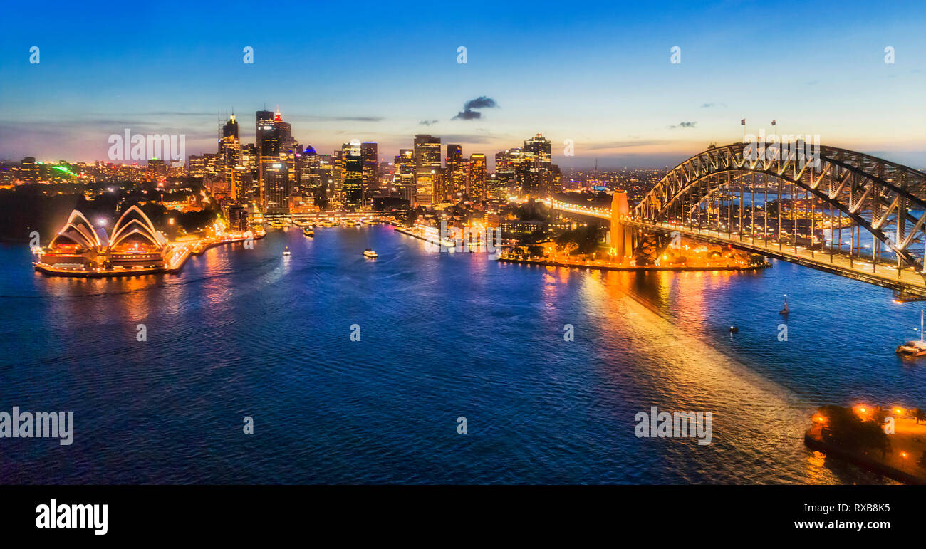 Dunkle Beleuchtung der Stadt Sydney CBD Sehenswürdigkeiten über Gewässer des Hafens von Sydney, mit Reflektion - große Antenne Panorama. Stockfoto